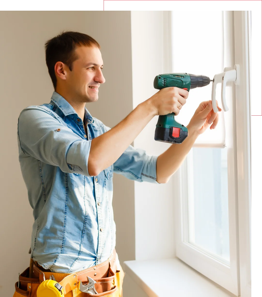 Handyman installing window with drill.