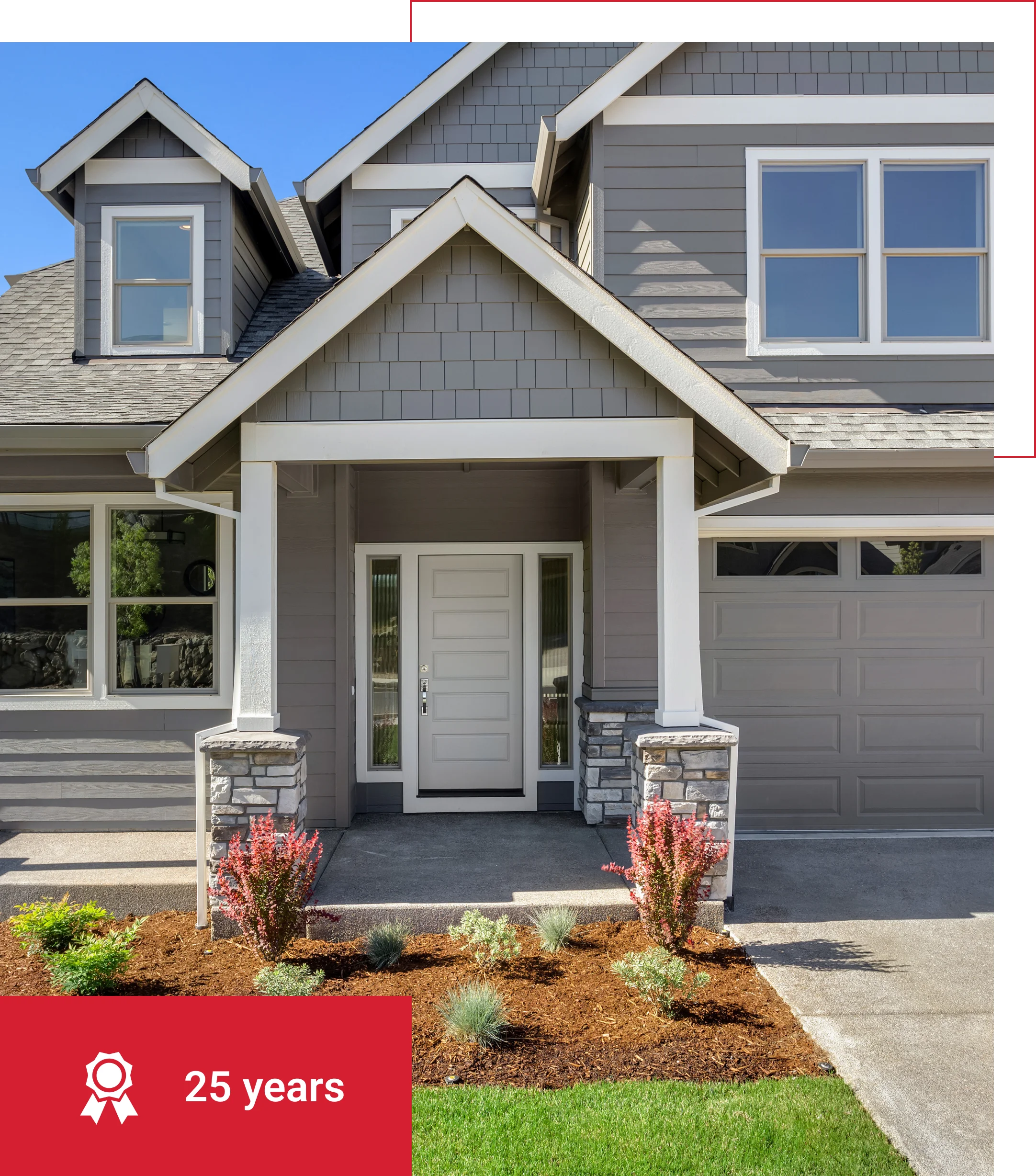 Gray house with landscaping and 25-year award.